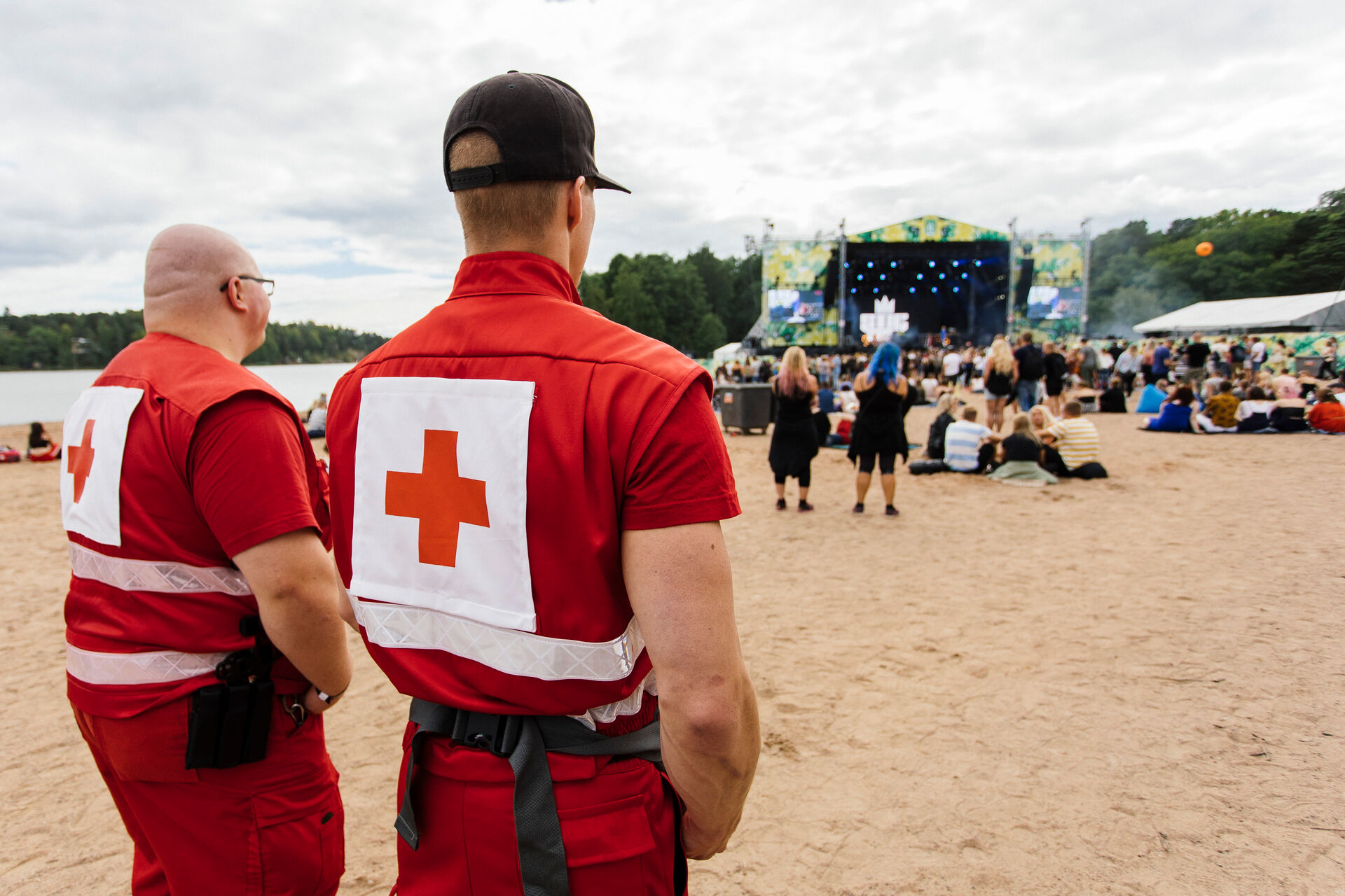 Kaksi Punaisen Ristin ensiapupäivystäjää, taustalla konserttilava.